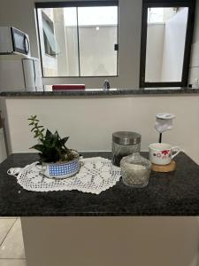 a counter top with a plant and a cup on it at Ap Perfeito! Condomínio fechado e garagem coberta in Tangara da Serra