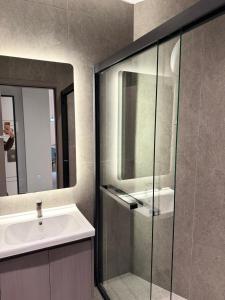 a bathroom with a sink and a glass shower at Casa Del Sol Studio - Shengjin in Shëngjin +4 photos