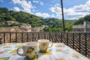 two coffee cups sitting on a table on a balcony at Casa del Borgo, between Mountains and Lake, Near Rome in Canepina