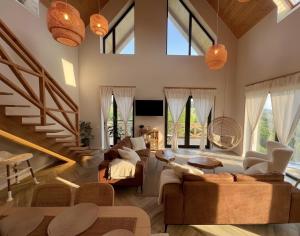 a living room with large windows and a couch at Casa Ido sat Pestera Moieciu in Peştera
