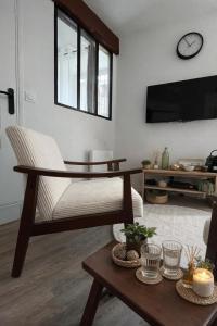 a living room with a couch and a table at Place aux fleurs - Le cocon in Dole