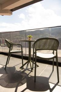 a chair and table on a balcony with a view at Nova Apartments in Prizren