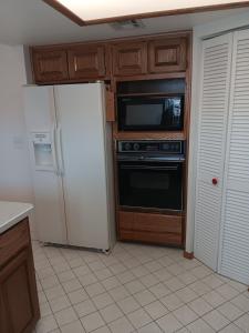 a kitchen with a refrigerator and a microwave at Beautiful Riverview Condo with Boatlaunch in Bullhead City