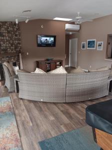 a living room with a couch and a tv on a wall at Beautiful Riverview Condo with Boatlaunch in Bullhead City