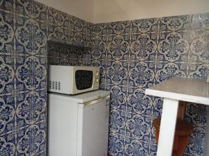 a microwave on top of a refrigerator in a kitchen at Quinta Da Lagoa GuestHouse in Vila Real