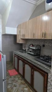 a kitchen with wooden cabinets and a counter top at Maison marhaba2 app2 in Inezgane