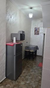a small kitchen with a table and a microwave at Maison marhaba2 app2 in Inezgane +7 photos