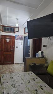 a living room with a bed and a television at Maison marhaba2 app2 in Inezgane