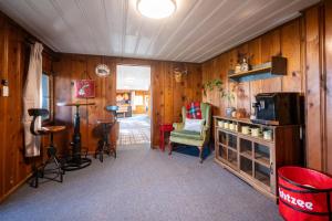 a living room with wood paneled walls and a television at The Woodsman Lodge in Eureka Springs