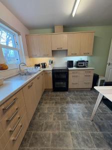 a kitchen with wooden cabinets and a tile floor at The Rookery in Orkney