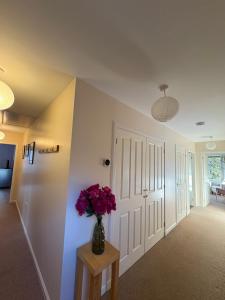 a hallway with a vase of flowers on a table at The Rookery in Orkney +3 photos