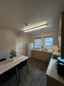 a kitchen with a table and a refrigerator at The Rookery in Orkney