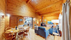 a living room and kitchen with a blue couch and a table at Tormore Cabin in Carrbridge
