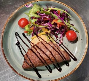 a plate of food with a sandwich and a salad at Shoxdiyor in Angren