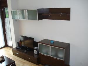 sala de estar con TV de pantalla plana y centro de entretenimiento en Jardín San Pelayo, en Niembro