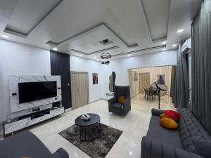 a living room with a couch and a tv at LUXURY 4BR Duplex with STARLINK ,PS5 and 247 power 4mins to GRA in Port Harcourt