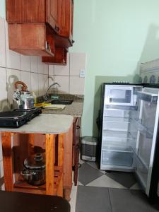 a kitchen with a stove and an open refrigerator at Hotel AEROPUERTO Jujuy in Perico +27 photos