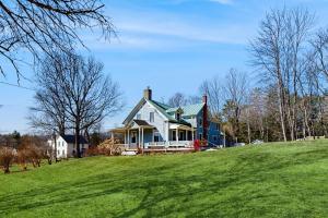 a blue and white house on a grassy hill at The Hilltop - Main House in Waterbury