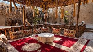 a room with a table and a couch with pillows at Maison Gourdia in Zouiyya