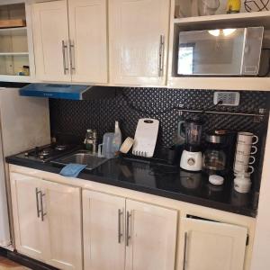 a kitchen with white cabinets and a black counter top at Urbanutopia Apartment A109 in Villas del Mar