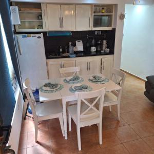 a kitchen with a table and chairs and a refrigerator at Urbanutopia Apartment A109 in Villas del Mar +7 photos