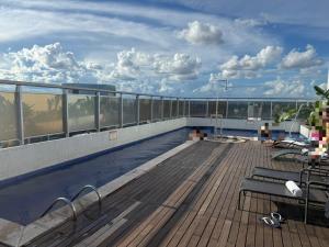 a rooftop deck with a swimming pool on a building at Flat no Hotel Blue Tree in Manaus