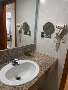 a bathroom with a sink and a mirror at Flat no Hotel Blue Tree in Manaus