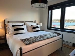 a bedroom with a bed with black and white pillows at The Boardwalk Hotel in Saint Ignace