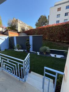 a garden with two white chairs and a lawn at Studio Élégant - Proche Paris & La Défense in Rueil-Malmaison