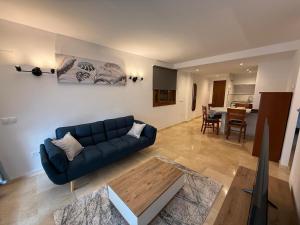 a living room with a blue couch and a table at Tus vacaciones junto al mar in Torrevieja
