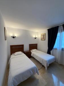 two beds in a room with a window at Tus vacaciones junto al mar in Torrevieja +52 photos