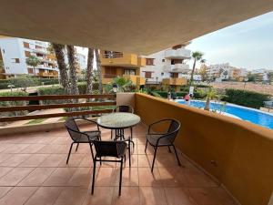a patio with a table and chairs on a balcony at Tus vacaciones junto al mar in Torrevieja