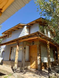 a house with a wooden door on the side of it at Cielo Azul 4 in Villa Pehuenia