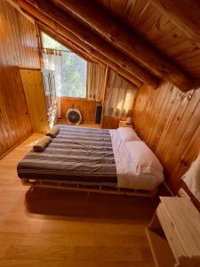 a large bed in a room in a wooden house at Cielo Azul 4 in Villa Pehuenia