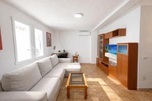a living room with a white couch and a tv at Bungalow Oaxaca: Playa de La Mata in Torrevieja