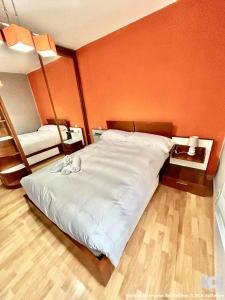 a large bed in a room with an orange wall at Carbonería 4 in Soria +7 photos