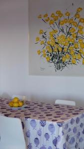 a table with a table cloth with a painting on the wall at Casa Paradiso - Panoramic Sea View & Jacuzzi in Terracina