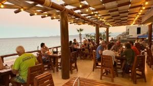 a group of people eating at a restaurant on the beach at Azul Beach Kite Resort in El Sargento