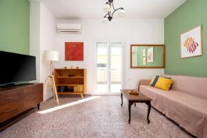 a living room with a couch and a tv at Dafni Local Style, 1 Min from Main Beach in Kardamaina