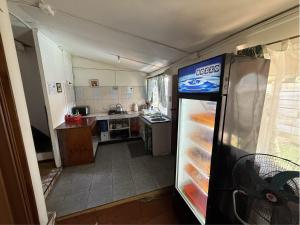 a small kitchen with a refrigerator with an open door at Hostal Vaihere in Hanga Roa +32 photos
