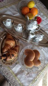 a table with two trays of pastries and tea pots at Nino's House in Sperlinga