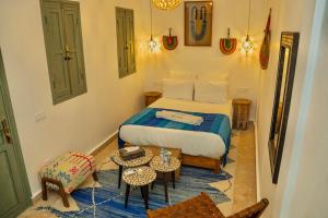 a small bedroom with a bed and a table at Riad Yamat privatisé au cœur de la Médina 3 chambres 10 min Jemaa el-Fna in Marrakesh