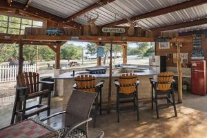 an outdoor bar with wooden chairs and a kitchen at MeMaws Country Cabin in Pipe Creek