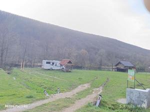 a rv parked in a field in front of a mountain at Kamp Suad in Zaglavica +16 photos