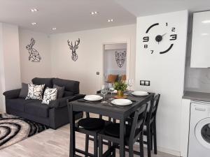 a living room with a table and a couch at LOFT Céntrico MALIAÑO - DUA ROOMS in Camargo +124 photos