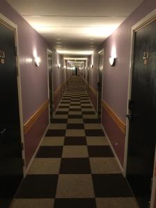 un pasillo largo con suelo de tablero de ajedrez en un edificio en Euroway Hotel, en Gotemburgo
