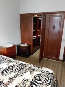 a bedroom with a bed and a dresser and a closet at Quarto no apartamento do anfitrião na Praia do Canto in Vitória +4 photos