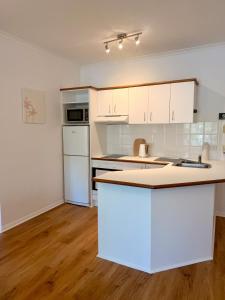 a kitchen with white cabinets and a counter top at Tropic Sands Coastal Escape in Port Douglas