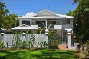 a white house with a fence in front of it at Tropic Sands Coastal Escape in Port Douglas +1 photo