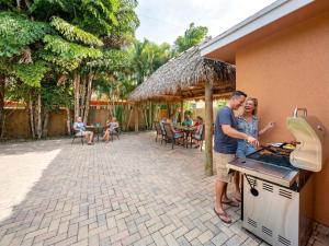 a man and woman standing in front of a grill at Hidden Gem Vacation Villa w Private Pool & TikiHut in Fort Lauderdale +28 photos